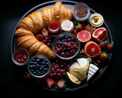 un plato de Fruta queso y croissants en un negro antecedentes generativo ai foto