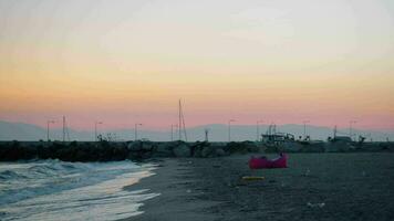 hombre relajante a el playa y noche escena de mar con gaviotas video