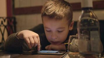 entediado Garoto usando Smartphone dentro cafeteria video