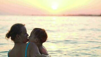 encantador madre y pequeño hijo nadando en mar video