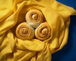 three rolls of cinnamon buns on a yellow cloth generative ai photo