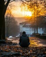 a person sitting on the ground in front of a tree at sunset generative ai photo