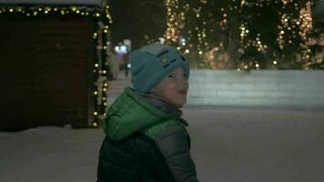 Kind Laufen im schneebedeckt Straße mit Weihnachten Beleuchtung video
