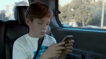 Boy spending time with mobile during car ride video