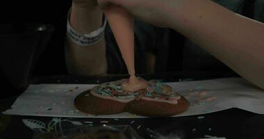 mor och unge dekorera pepparkaka kaka med glasyr video