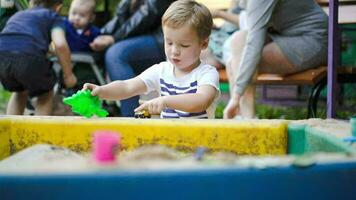 Kind spielen mit Spielzeuge im Sandkasten video