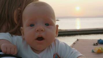 Baby girl in mothers hands outdoor at sunset video