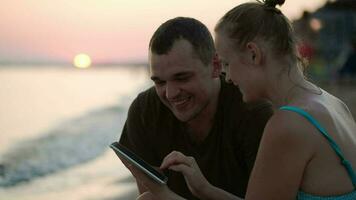 uomo e donna con tavoletta pc su il spiaggia video