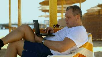 Man relaxing with a laptop at beach resort video