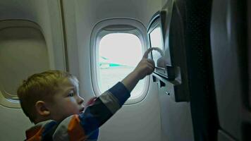 pequeño chico conmovedor asiento monitor en avión video