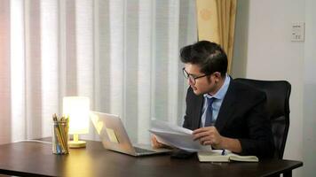 Asian businessman working on laptop computer at home office,working at home on the Internet. photo