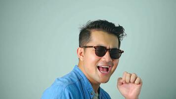 Asian man handsome wearing sunglasses gesture thumb up white background. photo