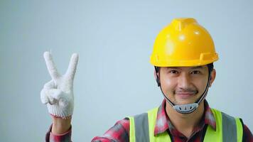 A fornman wearing  raising two fingershardhat white background. Architect, Engineer of Concept. photo