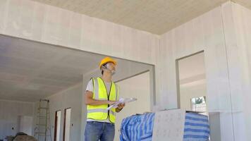 Asian supervisor Construction wearing safety helmets with construction plans, looking for additional interiors. photo