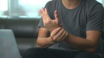 Close up hand of asian man he massages wrist hurts using laptop for long period of time. photo