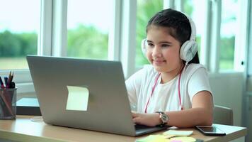 Kid girl actively chatting with friends in social networks sitting in his room photo