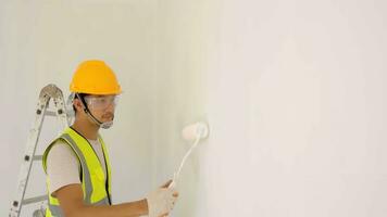 Asian construction worker uses roller to paint the ceiling at the construction site . photo