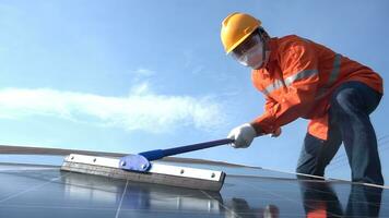 un práctico técnico es limpieza el solar paneles a generar electricidad desde un solar poder planta. foto