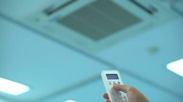 Hand with remote power on air conditioning split. photo