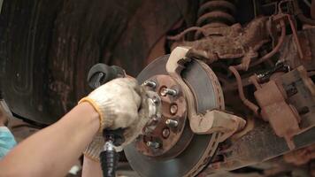 asiático hombre coche mecánico reemplazando un coche neumático en garaje taller. . auto servicio, cuidado del automóvil centrar elimina el rueda, reparar y mantenimiento de el coche en servicio. foto