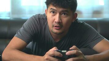 A young man having fun playing video games sit sofa at home. photo