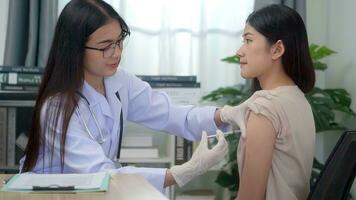 Beautiful asian woman doctor injecting in arm of asian girl. photo