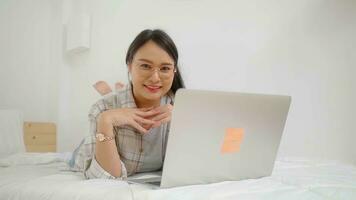 Happy asian beautiful freelance woman using laptop business online  in bed at home. photo