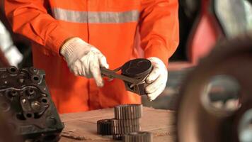 Asia mechanic measuring the piston of an internal combustion engine. Work in a mechanical workshop. photo