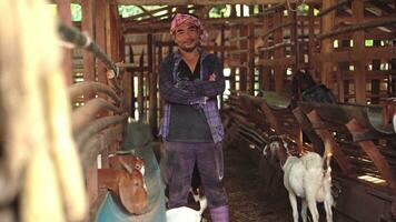 un granja trabajador o un granja propietario levantamiento joven cabras en un casa de Campo. foto