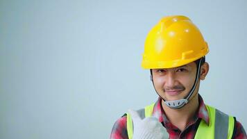 Asian young engineer wearing a yellow safety goggles and safety vest. looking to the side and smiling. photo