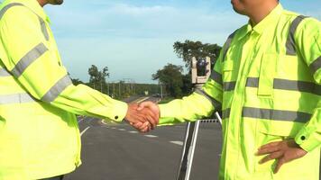 encuesta ingenieros apretón de manos en la carretera construcción sitio, después utilizar teodolito marca un Autopista a autopista éxito, civil ingenieros, topógrafo equipo. trabajo en equipo de topógrafo ingenieros concepto. foto