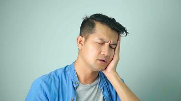 Young asian man action feeling very bad pain from toothache on white background photo