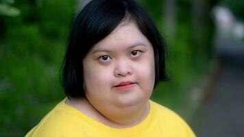 Asian young female Down syndrome two thumb up smile while exercising in the park. photo