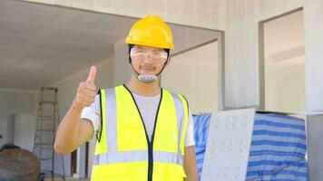 un joven elegante, capataz, mira a el construcción , vistiendo un protector casco. concepto bueno trabajar, proyecto. foto