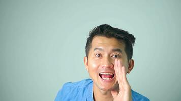 Asian man yelling and hand on his mouth, on White background copy space photo