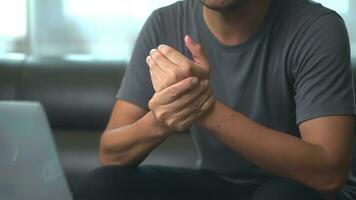 Close up hand of asian man he massages wrist hurts using laptop for long period of time. photo