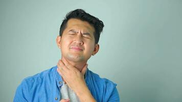 Sick asian man with sore throat on white background. photo