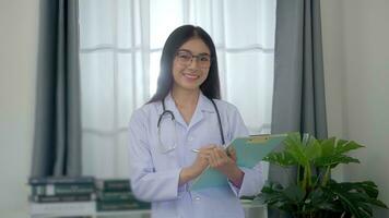 profesional asiático mujer médico examinar reporte documento de paciente a plan el siguiente tratamiento. foto