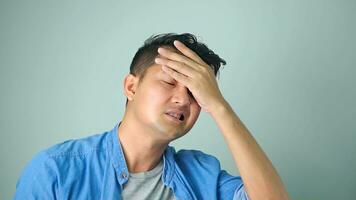 Asian man looking perplexed, having complicated situation. Guy with headache touching head and looking away, suffering painful migraine, standing white background. photo