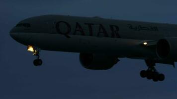 phuket, thailand november 28, 2019 - qatar luftvägarna boeing 777 närmar sig innan landning på de phuket flygplats hkt. flygplan silhuett i de mörk video