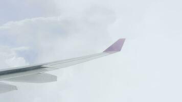 View of the wing of an airplane flying through the clouds. Fly through the clouds video