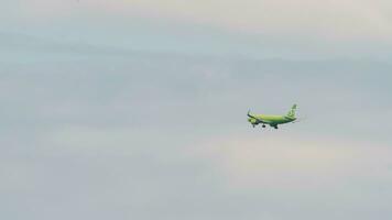 Novossibirsk, russe fédération juin 27, 2021 - passager Airbus de s7 approche avant atterrissage à tolmachevo international aéroport, Novossibirsk vb. longue tir, vert avion mouches dans le ciel. video