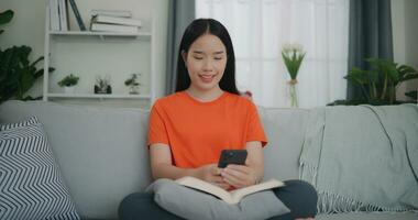 Asian woman reading a book while sitting on the sofa photo