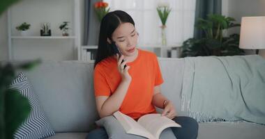 Asian woman reading a book while sitting on the sofa photo