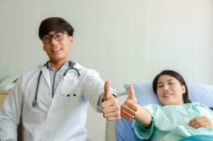 Thumbs up of doctor and patient in hospital ward photo