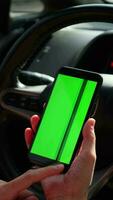 mão segurando Móvel telefone com verde tela às carro video