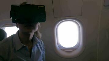 Slow motion view of woman using VR-helmet for smartphone in airplane video