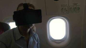 View of woman using VR-helmet for smartphone in airplane video