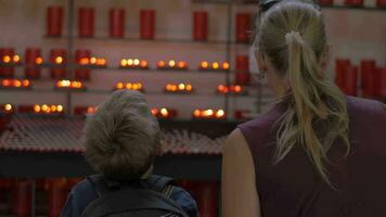 Mother and child looking at candles in church video