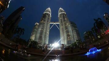 Zeitraffer von Menschen durch Petronas Türme von Abend bis Nacht video